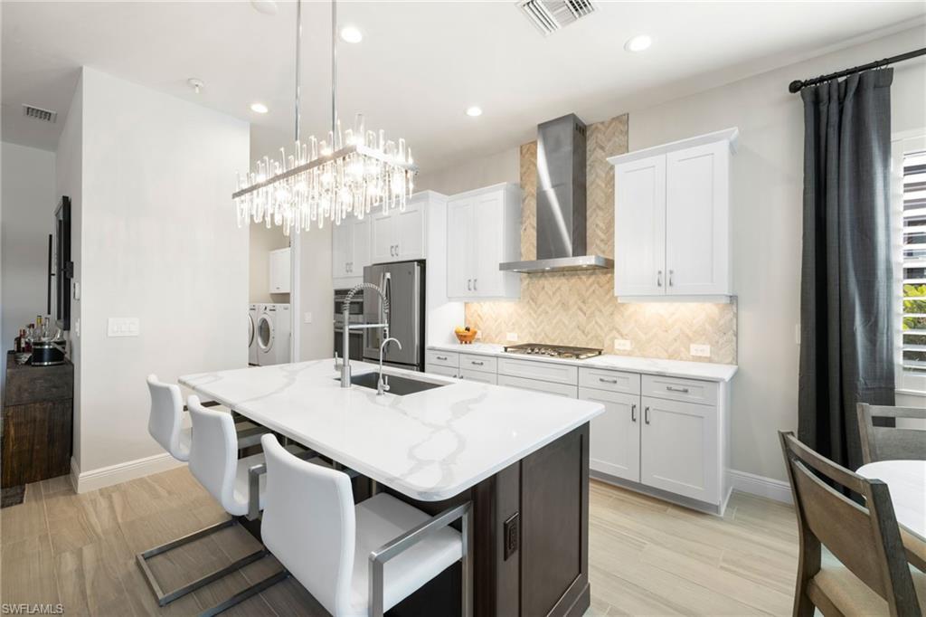 3967 Pegasus Way Naples, FL 34120 - Photo 12 of 50 a kitchen that has a lot of white cabinets and stainless steel appliances