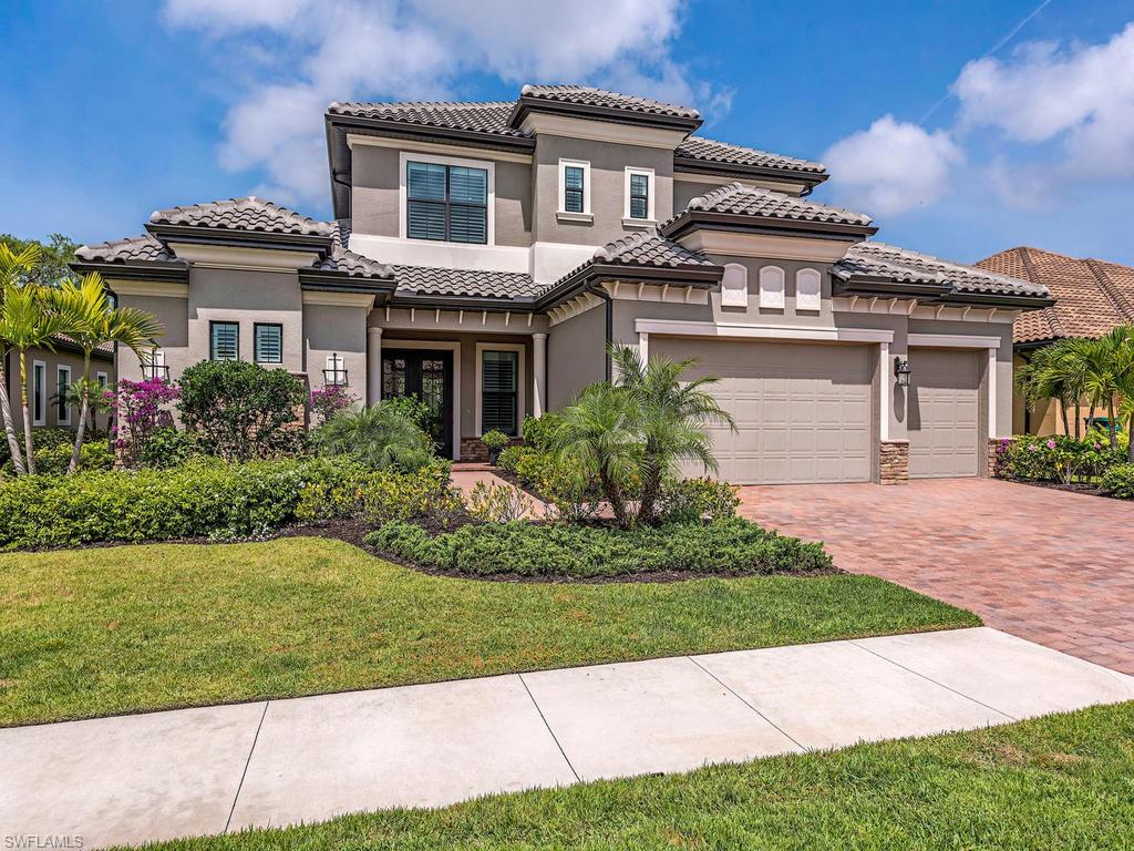 16211 Marsilea Place Naples, FL 34110 - Photo 1 of 17 a front view of a house with a garden and plants