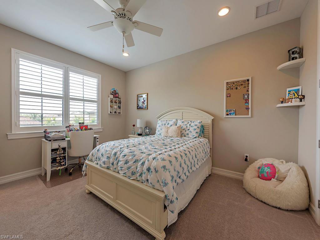 16211 Marsilea Place Naples, FL 34110 - Photo 11 of 17 a bedroom with a bed and a chandelier