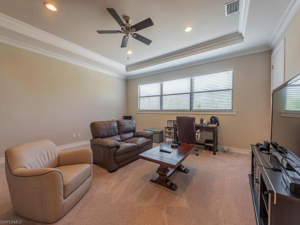16211 Marsilea Place Naples, FL 34110 - Photo 12 of 17 a living room with furniture a ceiling fan and a window