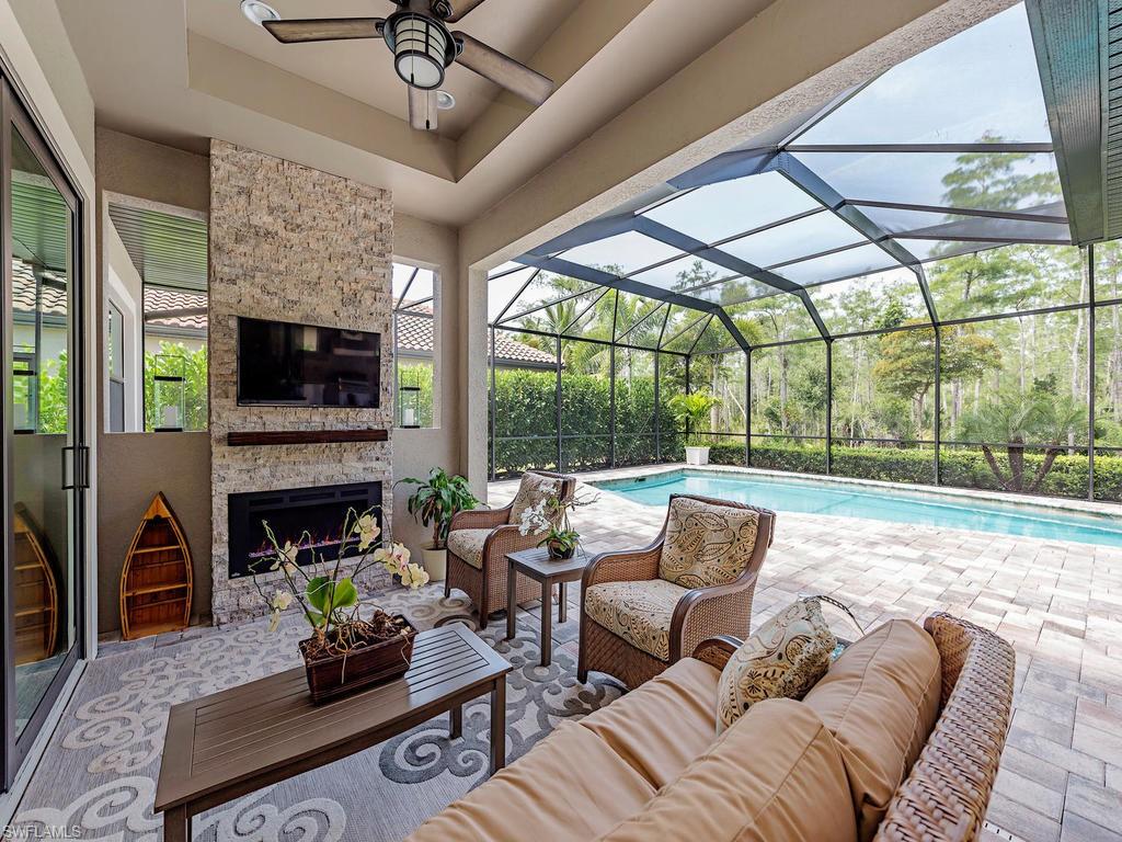 16211 Marsilea Place Naples, FL 34110 - Photo 15 of 17 a living room with fireplace furniture and a floor to ceiling window