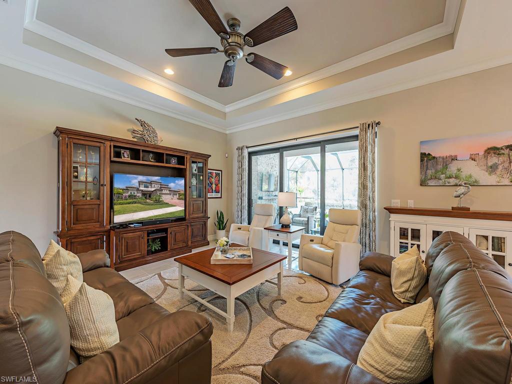16211 Marsilea Place Naples, FL 34110 - Photo 4 of 17 a living room with furniture a flat screen tv and a large window