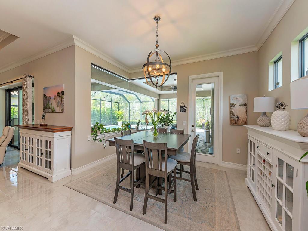 16211 Marsilea Place Naples, FL 34110 - Photo 5 of 17 a dining room with furniture a chandelier and wooden floor