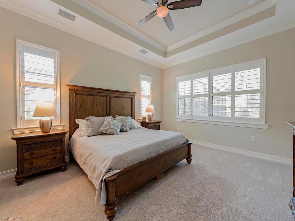 16211 Marsilea Place Naples, FL 34110 - Photo 7 of 17 a bedroom with a bed lamp and a window