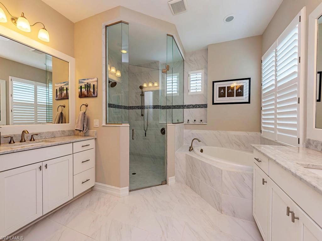 16211 Marsilea Place Naples, FL 34110 - Photo 8 of 17 a spacious bathroom with a granite countertop sink mirror and bathtub