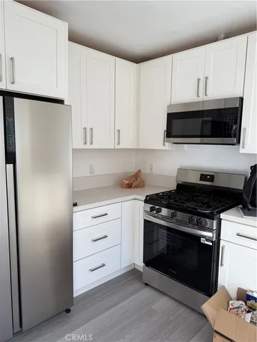 a kitchen with white cabinets and appliances