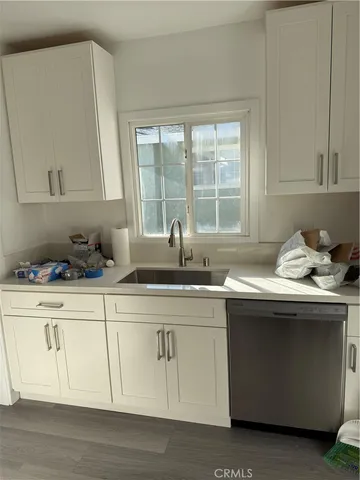 a kitchen with stainless steel appliances granite countertop a sink a stove and a white wooden cabinets