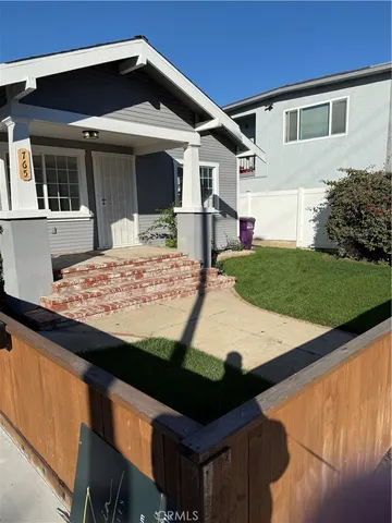 a front view of a house with a garden and yard