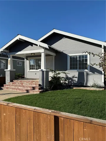 a front view of a house with a garden and yard