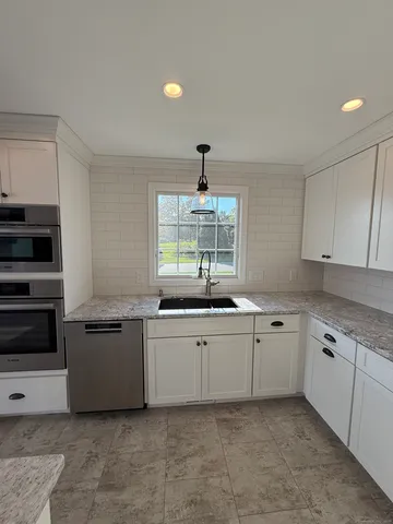 a kitchen with a sink stove and cabinets