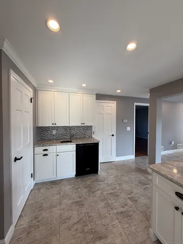 a large bathroom with a granite countertop sink a toilet a large mirror and bathtub