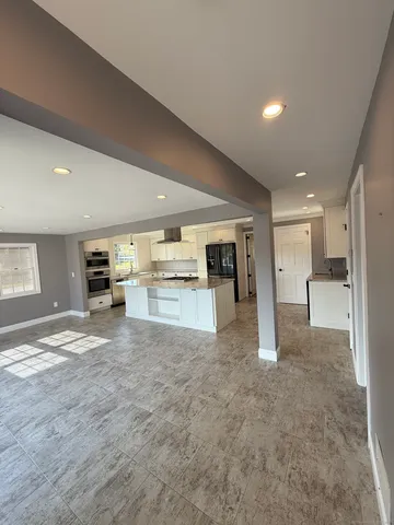 a view of kitchen with kitchen island a refrigerator sink and stove
