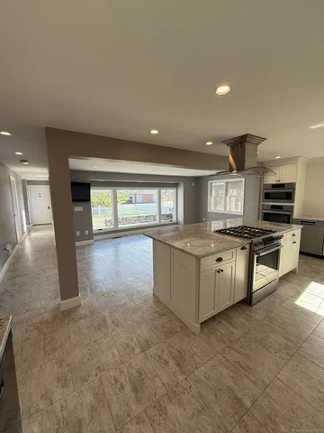a kitchen with granite countertop a stove top oven and cabinets