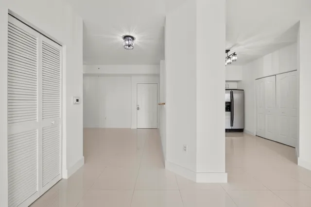 an empty room with windows and ceiling fan