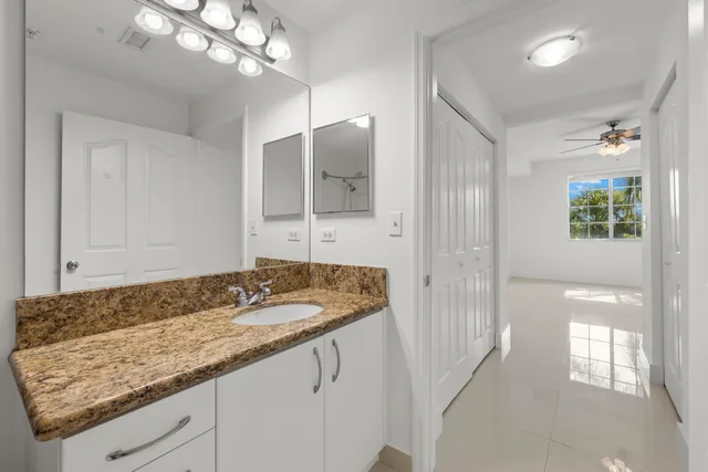 a bathroom with a granite countertop sink and a mirror