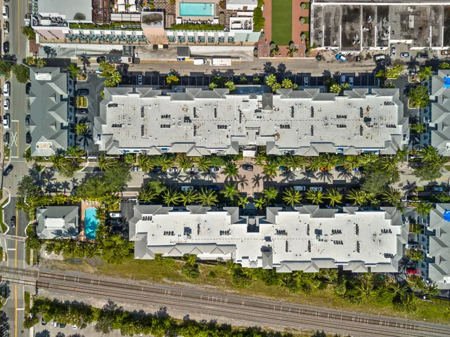 a building with swimming pool and lawn chairs