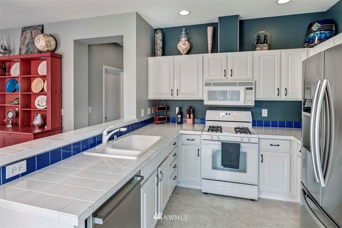 34713 Southeast Ridge Street Snoqualmie, WA 98065 - Photo 7 of 22 a kitchen with stainless steel appliances granite countertop a white cabinets and sink