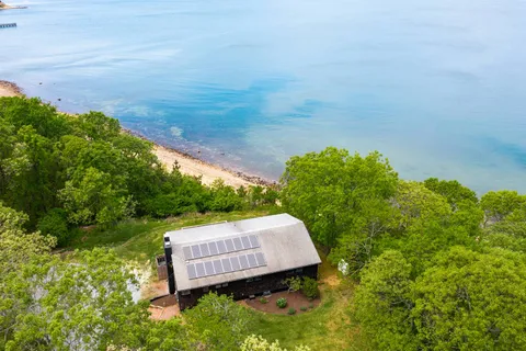 a view of a backyard with lawn chairs under an umbrella
