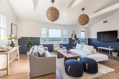 a living room with furniture chandelier and a large window
