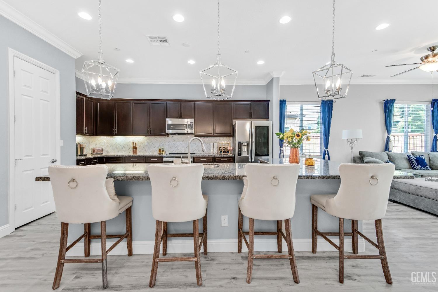 Undisclosed Address Bakersfield, CA 93306 - Photo 23 of 49 a kitchen with stainless steel appliances kitchen island granite countertop a dining table chairs and a refrigerator