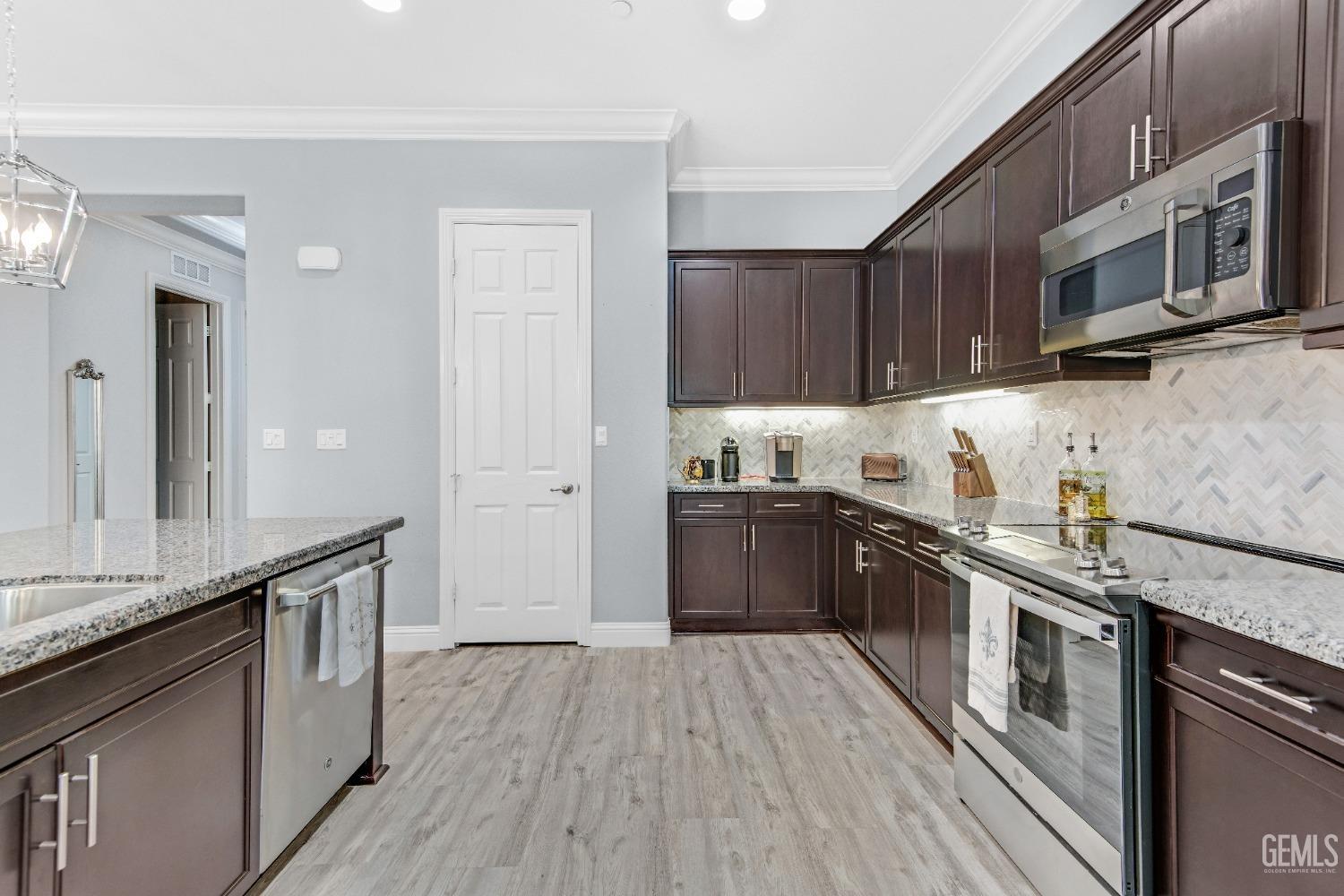 Undisclosed Address Bakersfield, CA 93306 - Photo 24 of 49 a kitchen with stainless steel appliances granite countertop a stove a sink and a microwave