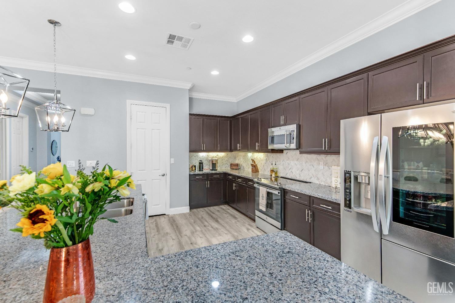 Undisclosed Address Bakersfield, CA 93306 - Photo 26 of 49 a large kitchen with stainless steel appliances kitchen island granite countertop a refrigerator a stove a sink a counter space and cabinets