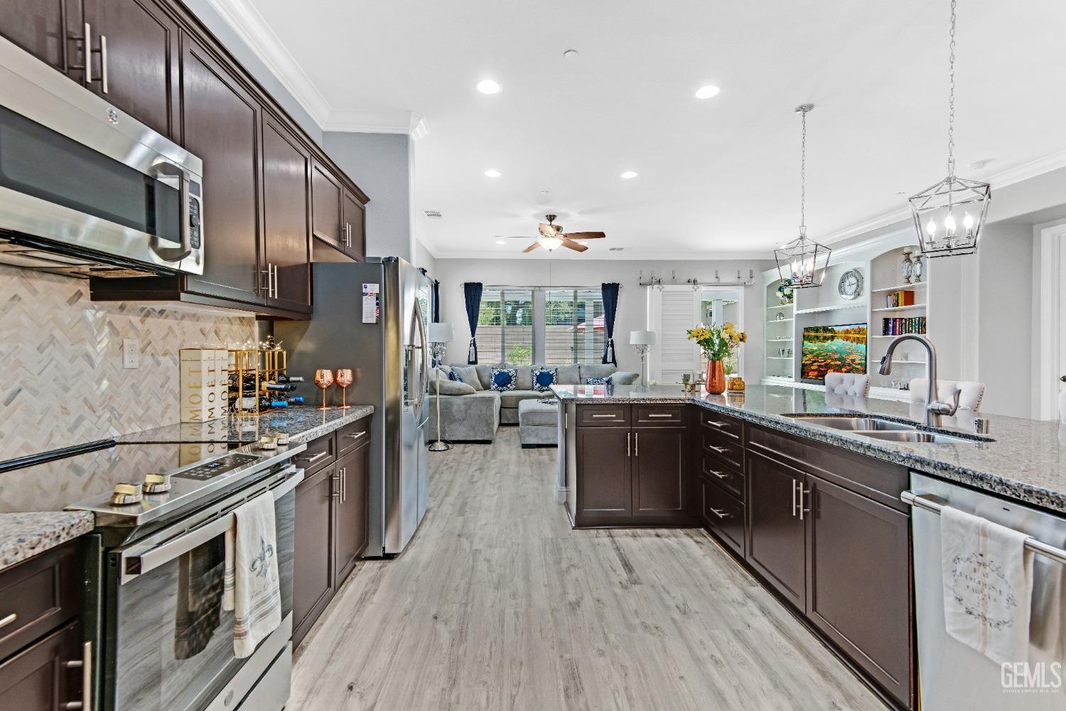 Undisclosed Address Bakersfield, CA 93306 - Photo 3 of 49 a kitchen with stainless steel appliances granite countertop wooden cabinets a sink dishwasher a stove and a wooden floors