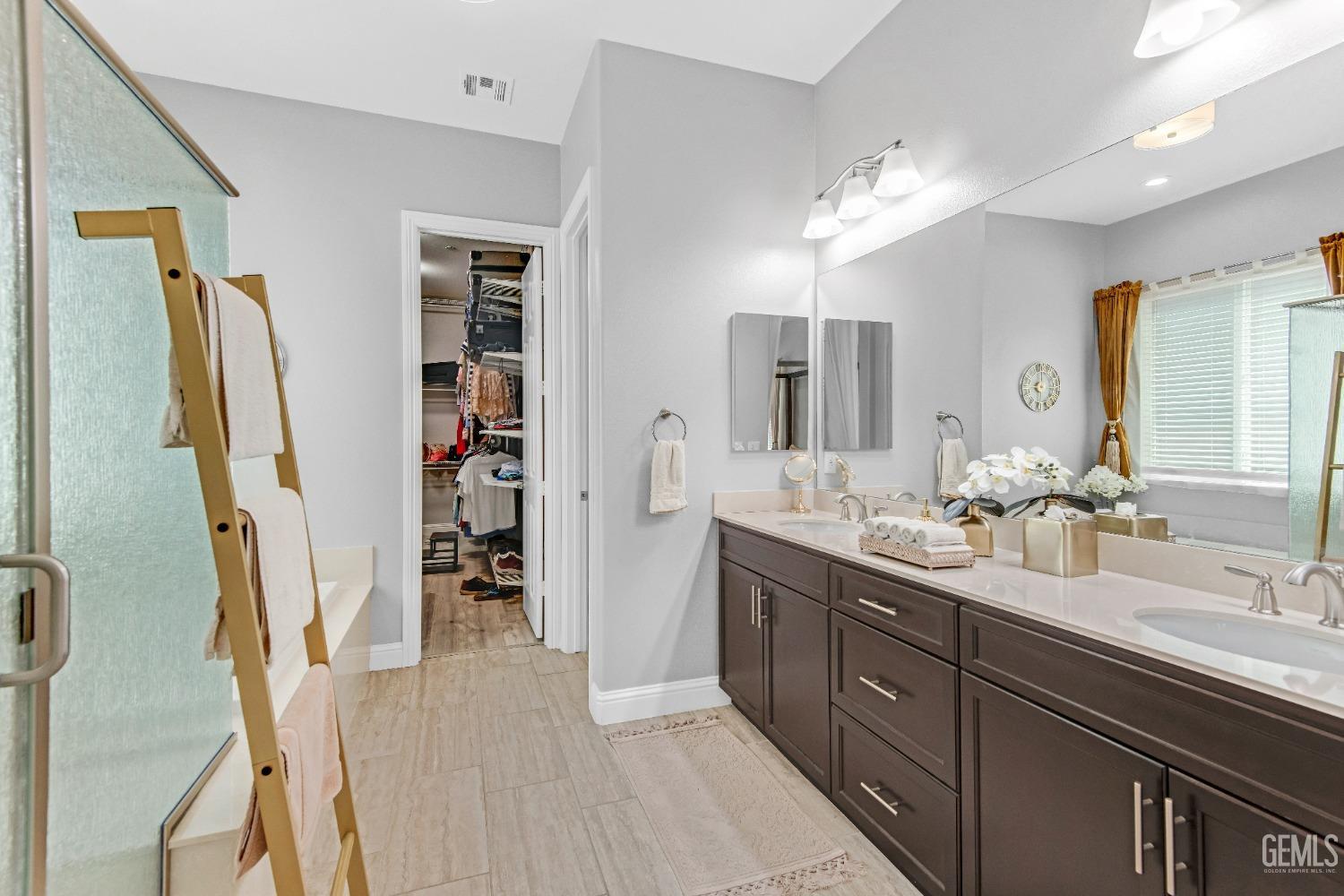 Undisclosed Address Bakersfield, CA 93306 - Photo 37 of 49 a bathroom with a double vanity sink a and mirror