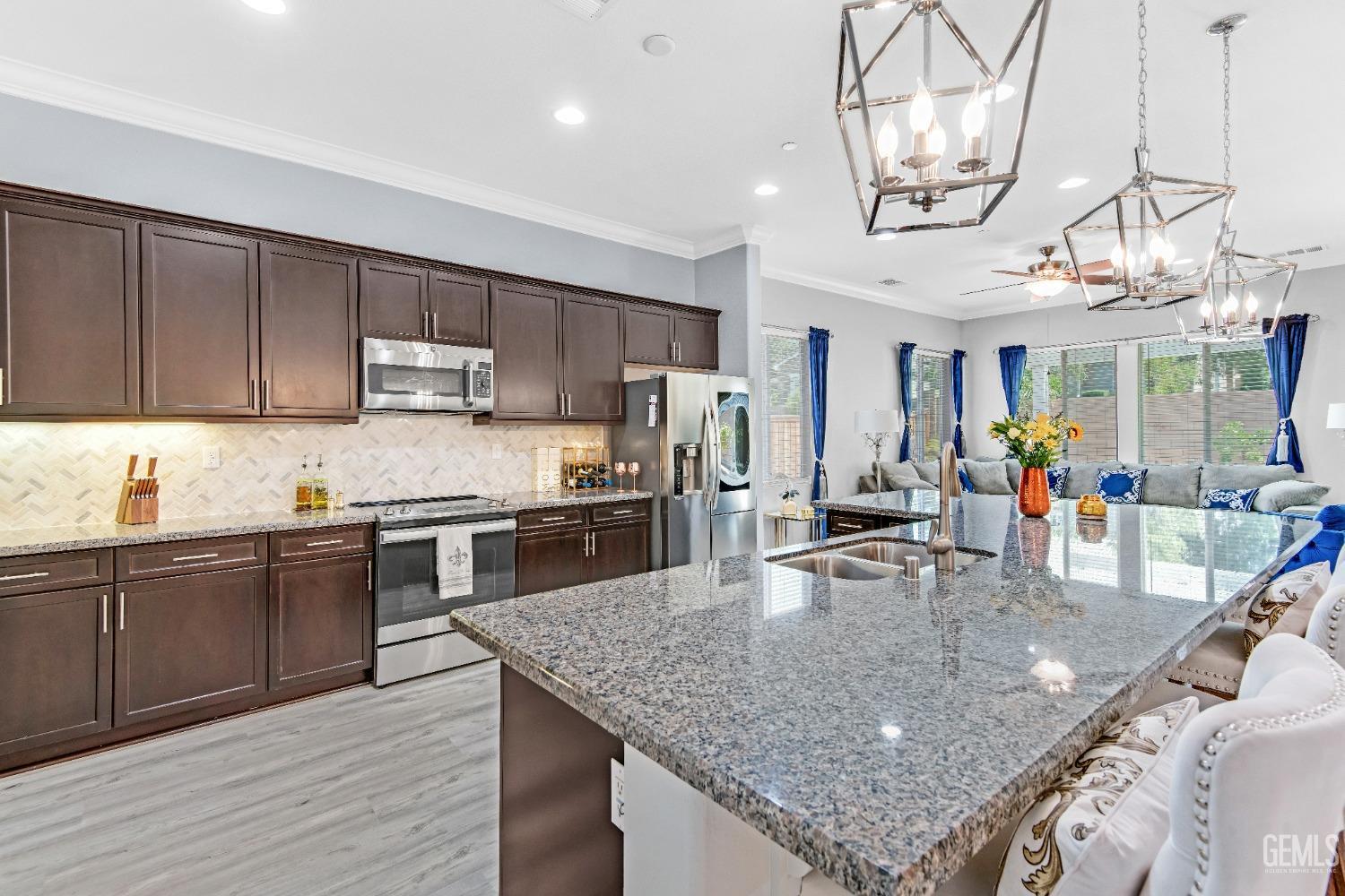 Undisclosed Address Bakersfield, CA 93306 - Photo 4 of 49 a kitchen with stainless steel appliances granite countertop a sink dishwasher and cabinets with wooden floor