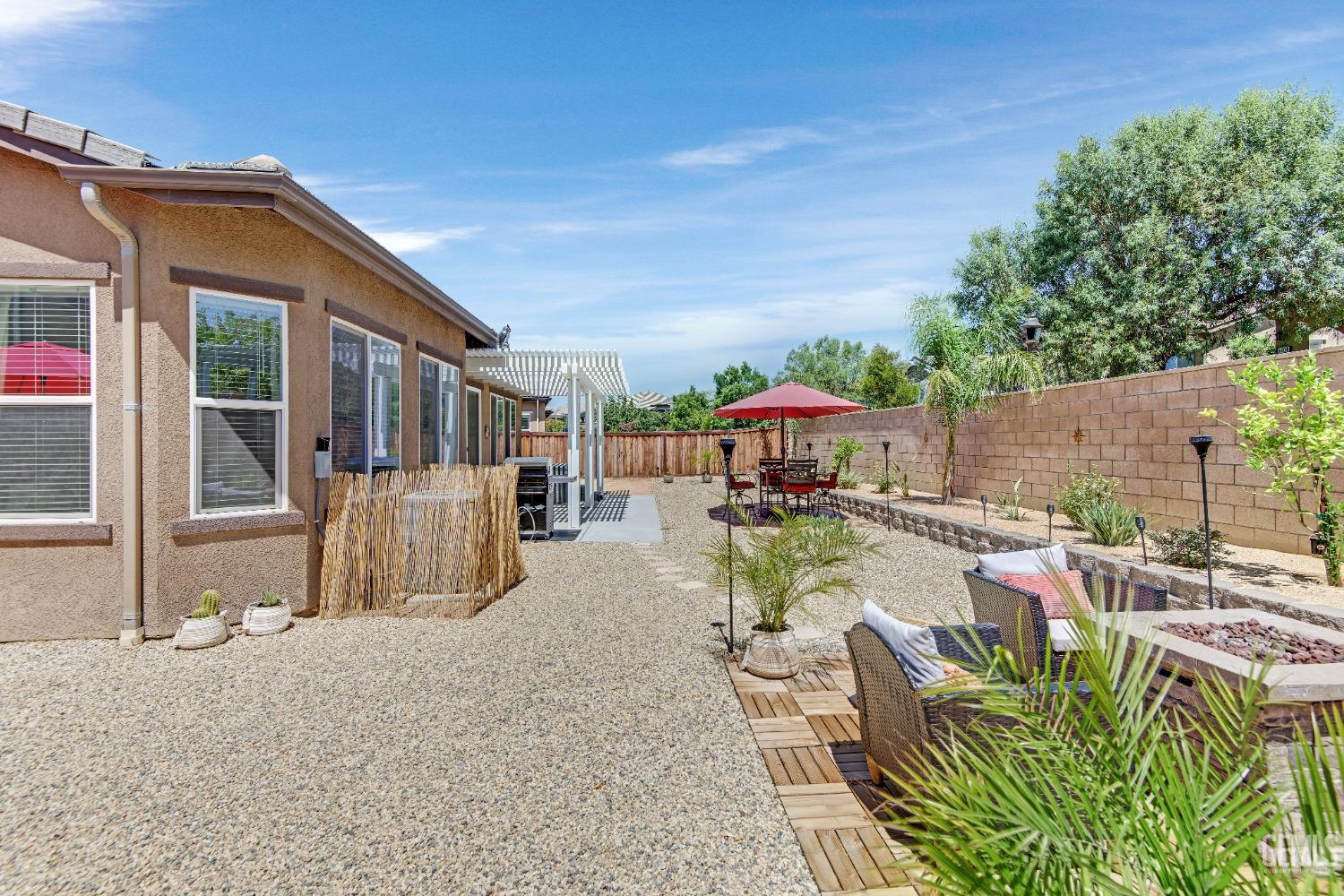 Undisclosed Address Bakersfield, CA 93306 - Photo 46 of 49 a view of a patio with table and chairs potted plants with wooden floor and fence