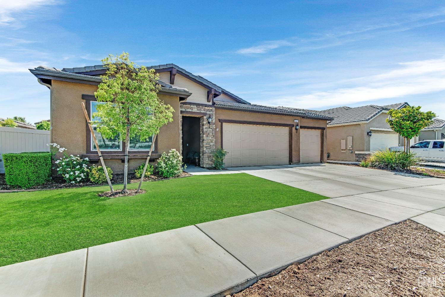 Undisclosed Address Bakersfield, CA 93306 - Photo 5 of 49 a front view of a house with a yard and garage