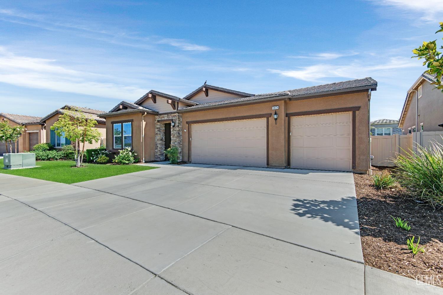 Undisclosed Address Bakersfield, CA 93306 - Photo 6 of 49 a front view of a house with a yard and garage