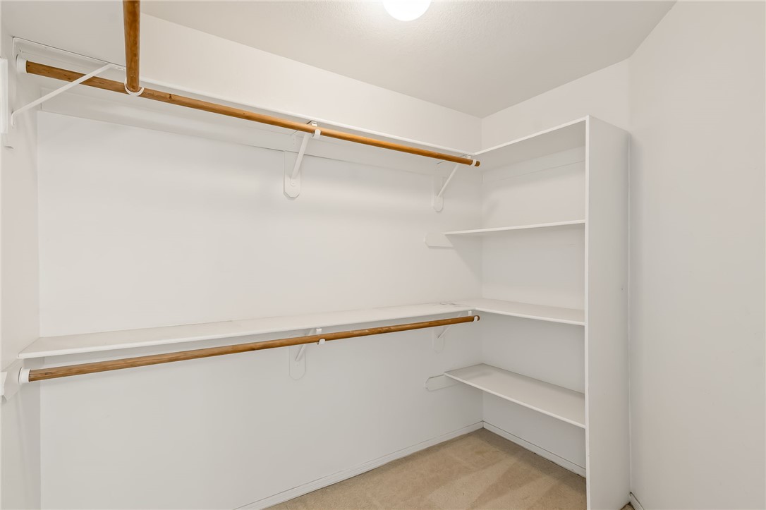 2853 Winchester Road Bullhead City, AZ 86442 - Photo 26 of 40 Spacious walk-in closet featuring white walls, a light-colored carpet, and built-in shelving with hanging rods