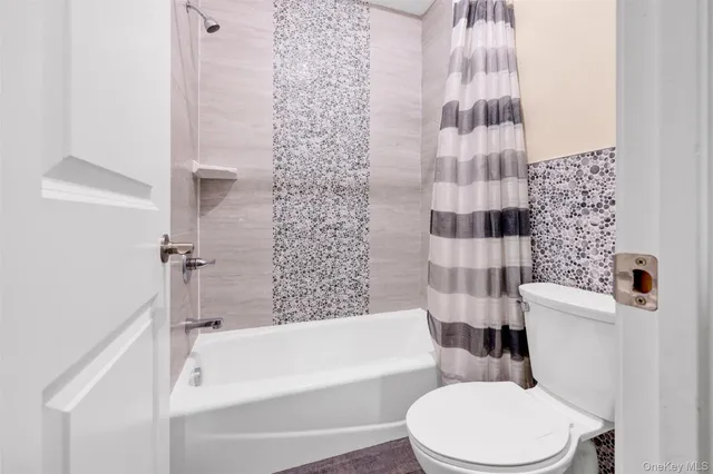 a white toilet sitting next to a bath tub