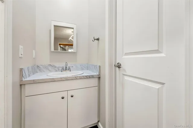 a bathroom with a granite countertop sink and a mirror