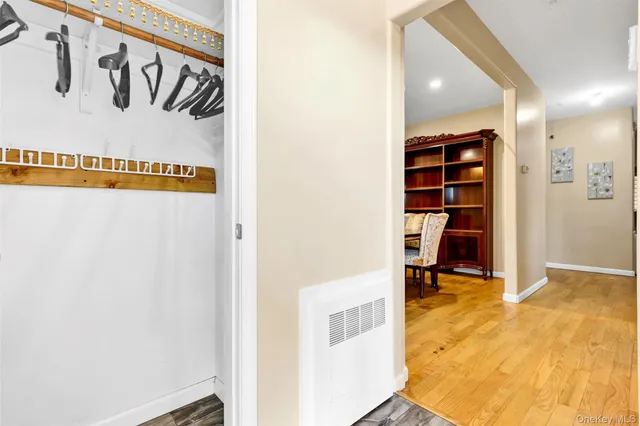 a view of a hallway with wooden floor and closet