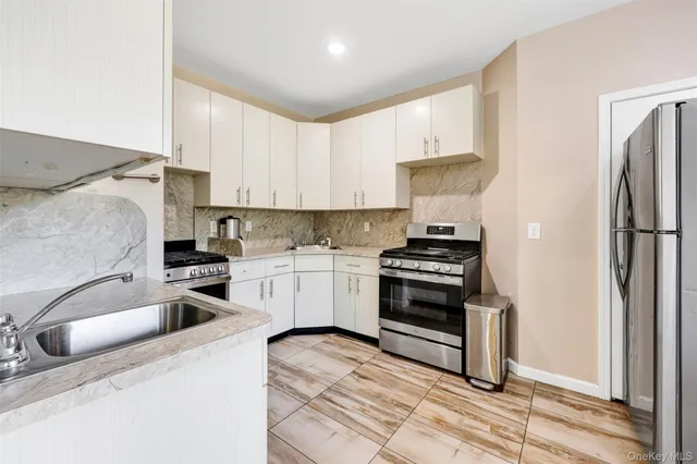 a kitchen with granite countertop a sink stainless steel appliances and cabinets