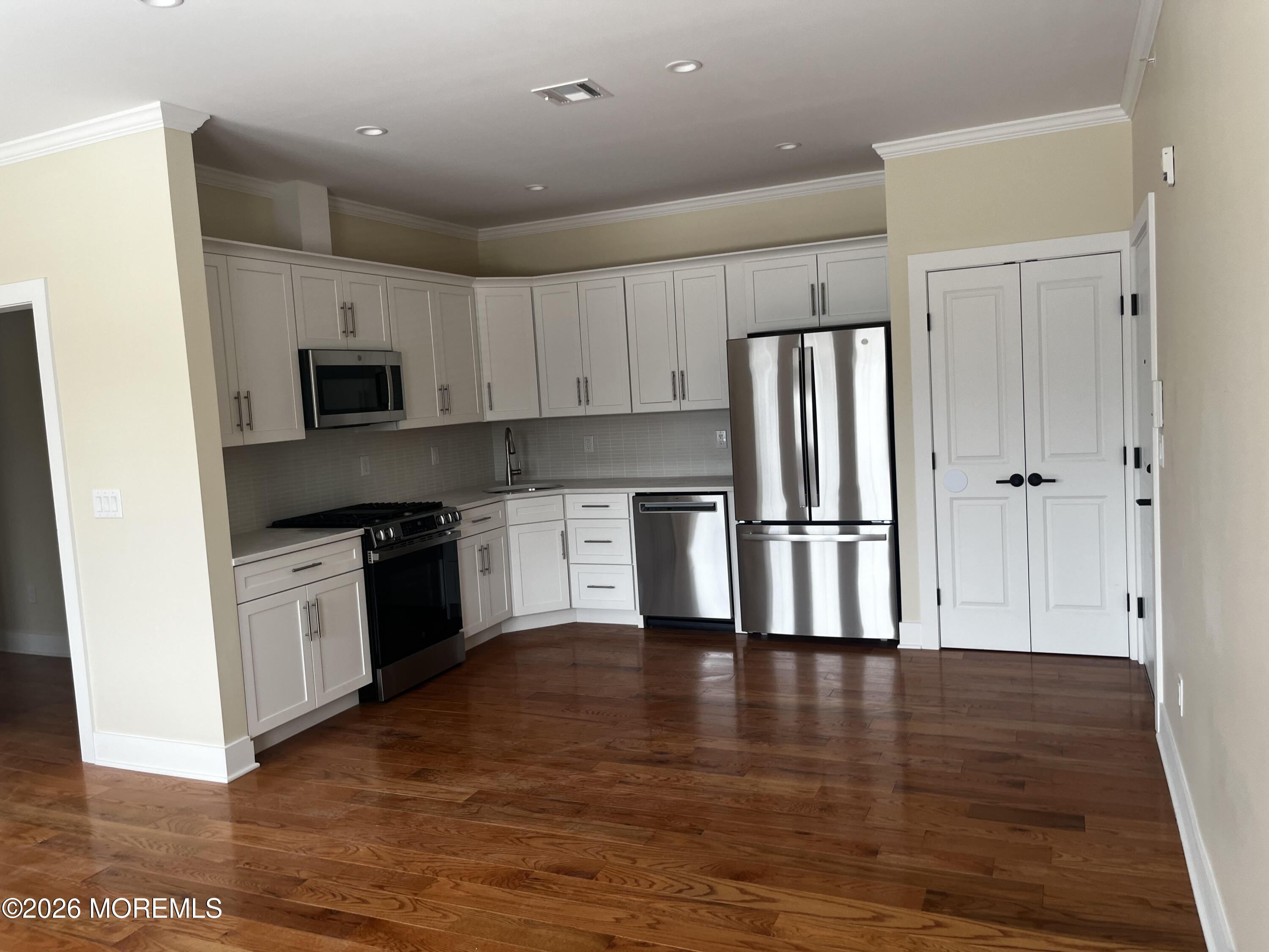 a kitchen with granite countertop a refrigerator and a stove top oven