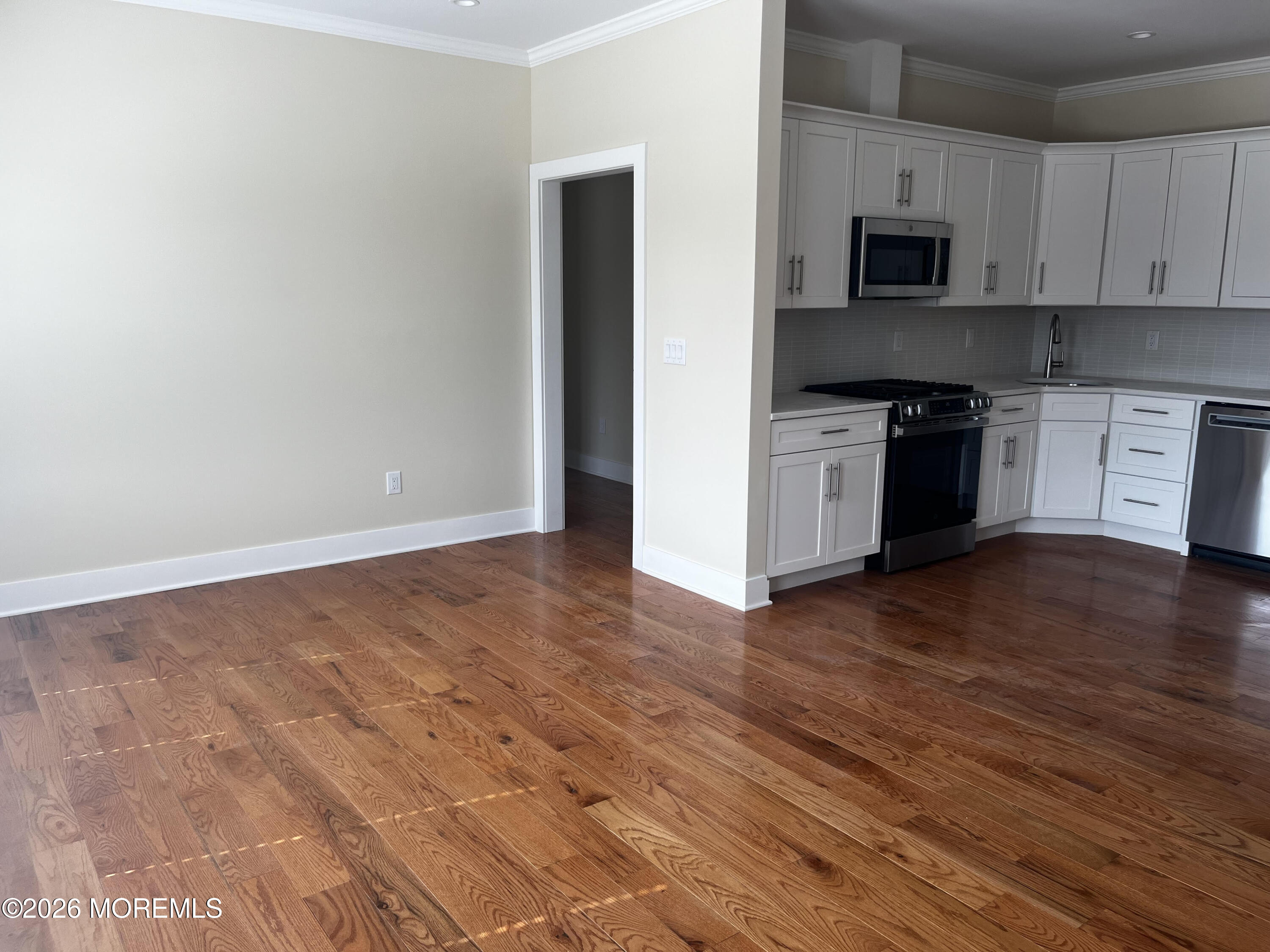 2419 Bridge Avenue, Unit 203 Point Pleasant, NJ 08742 - Photo 3 of 8 a kitchen with granite countertop a stove top oven a sink and a microwave