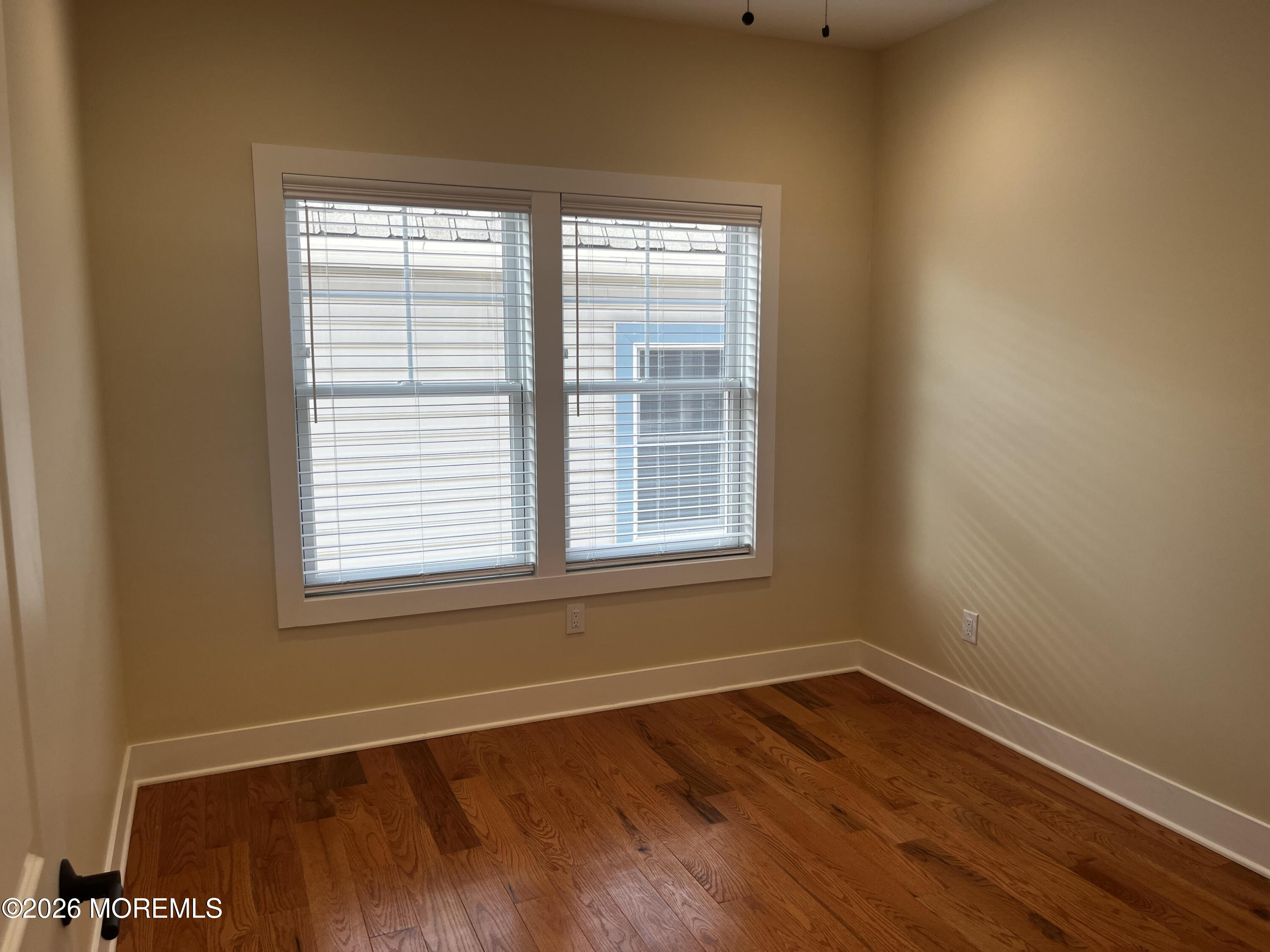 2419 Bridge Avenue, Unit 203 Point Pleasant, NJ 08742 - Photo 7 of 8 a view of an empty room with wooden floor and a window