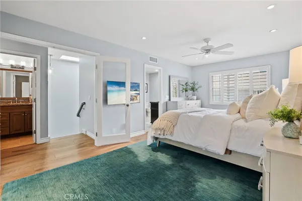 a spacious bedroom with a large bed and a chandelier