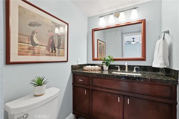 a bathroom with a granite countertop sink and a mirror
