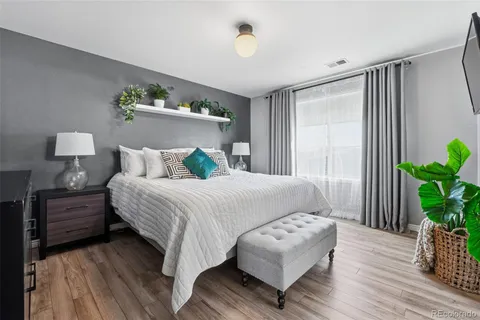 a bedroom with bed and wooden floor