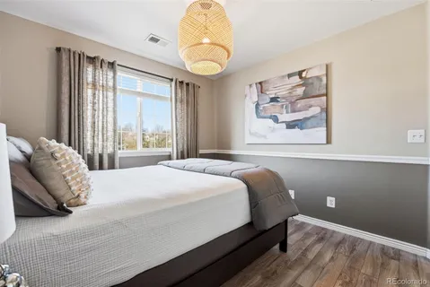 a bedroom with a bed and a painting on the wall