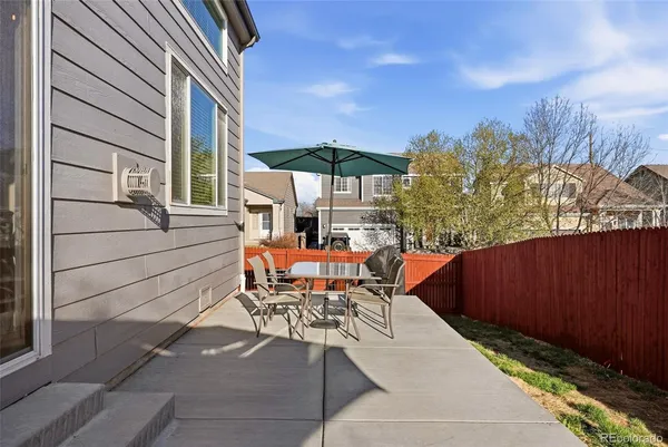 an outdoor sitting area with furniture and umbrella