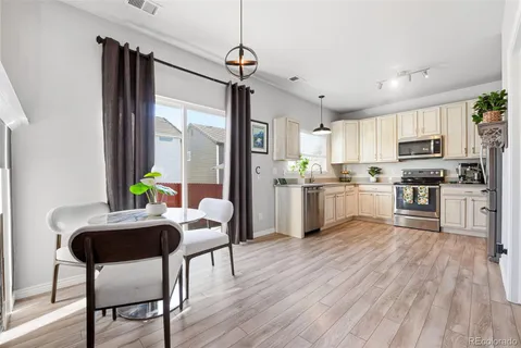 a kitchen with furniture wooden floor and stainless steel appliances