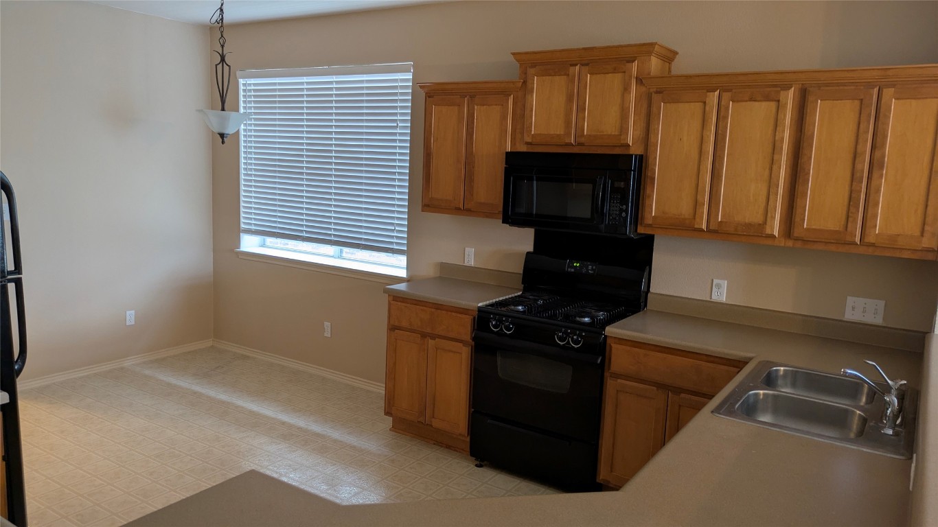 833 Rusk Road Round Rock, TX 78665 - Photo 5 of 15 a kitchen with granite countertop a stove top oven cabinetry and a refrigerator