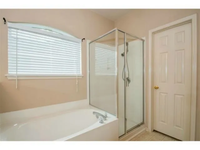 a bathroom with a shower and a bath tub
