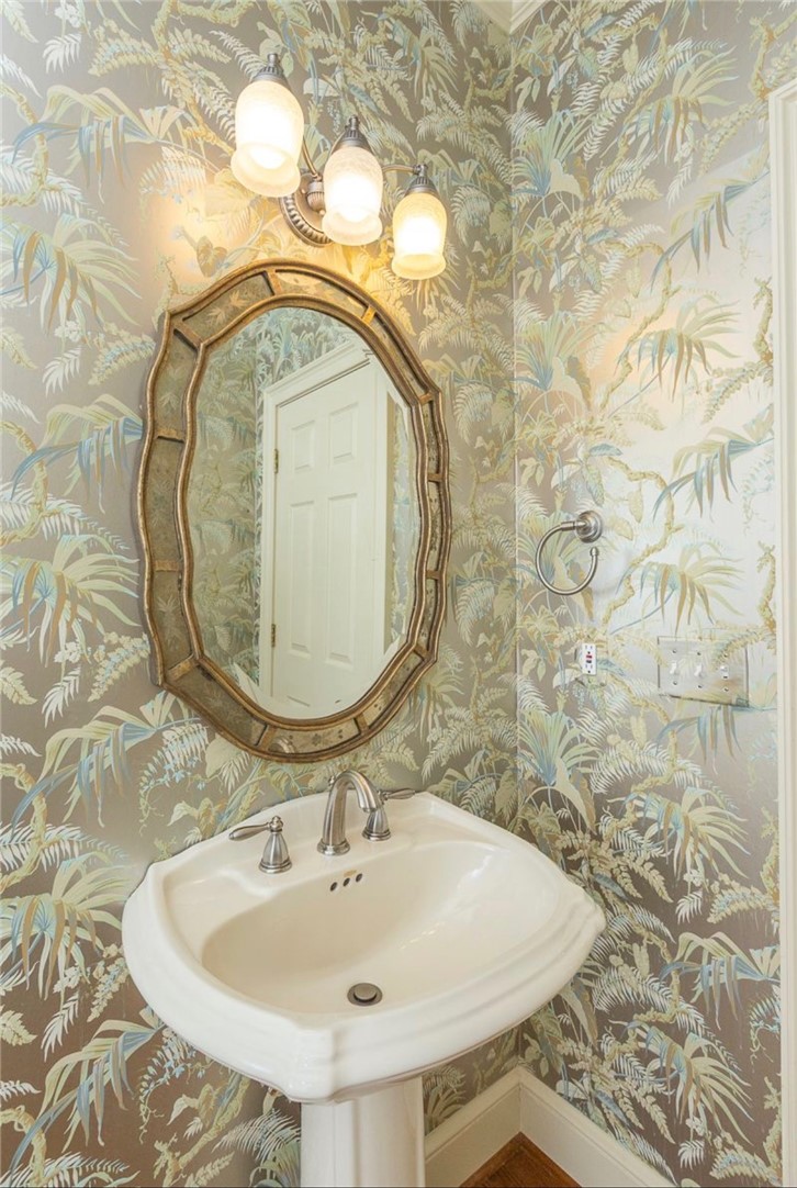 1104 Thornehill Drive Anderson, SC 29621 - Photo 20 of 35 This powder room features elegant botanical wallpaper and a classic pedestal sink, offering a charming aesthetic.