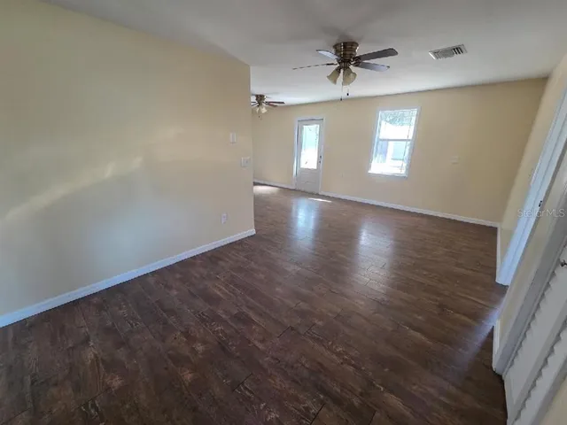wooden floor in an empty room with a window